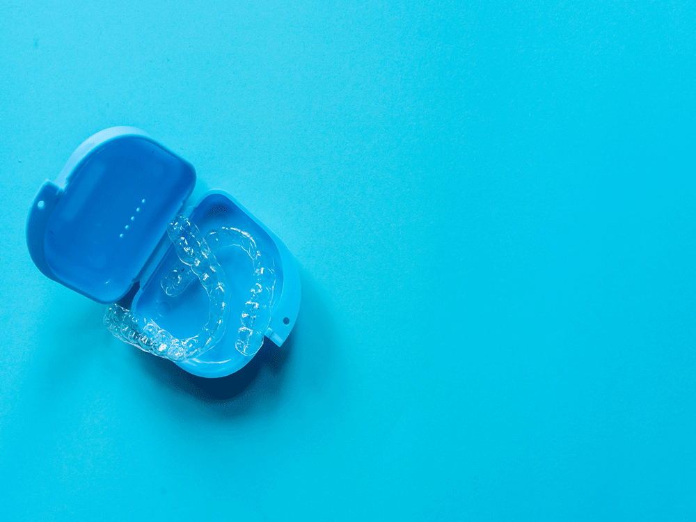 Clear aligners in a blue case.